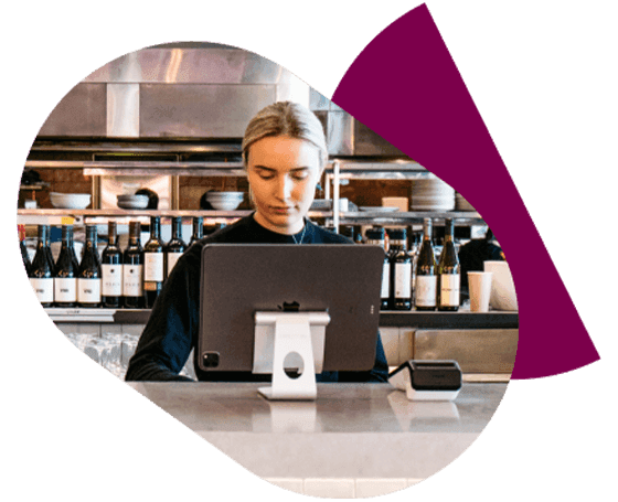 A women standing behind the counter at the POS in a hospitality venue