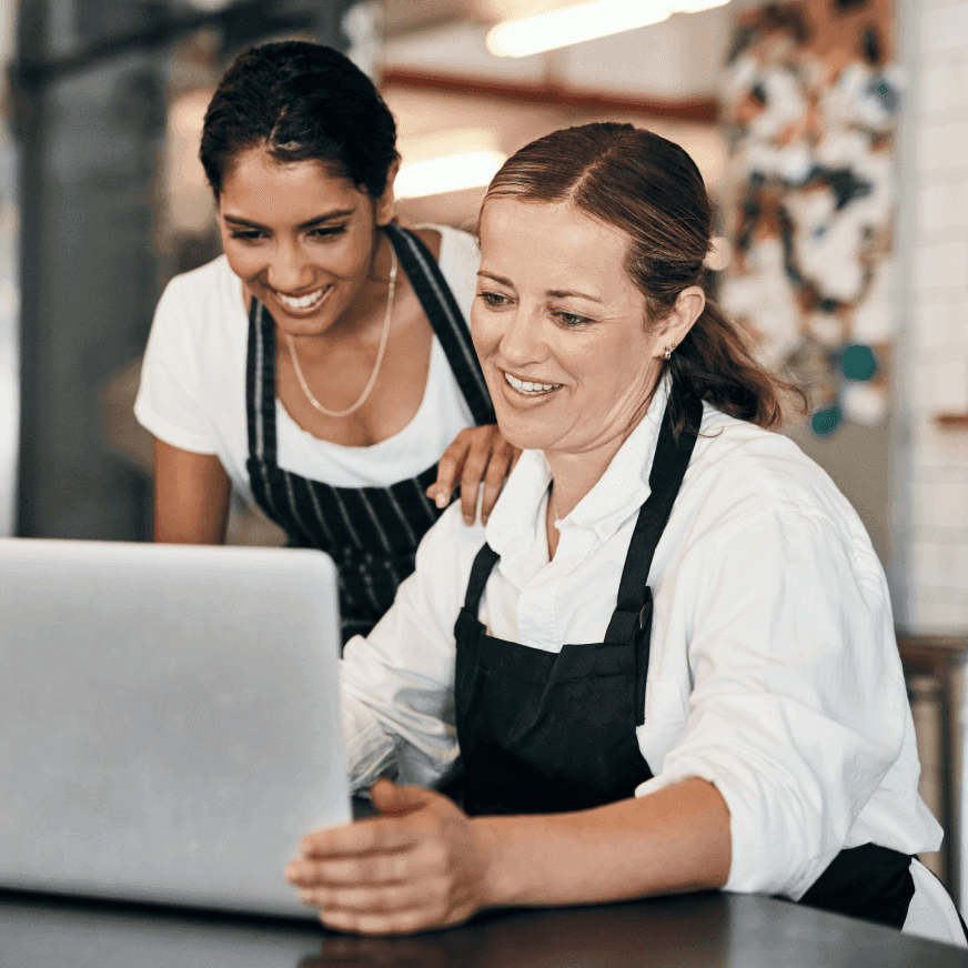 Two female chefs working on a laptop