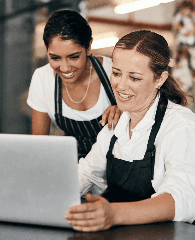 Two female chefs working on a laptop
