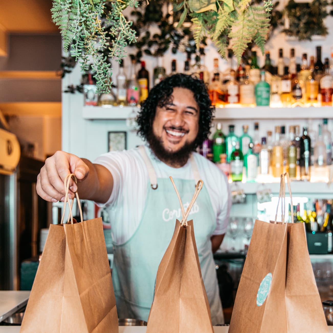 Man smile at counter with takeaway bags lined up